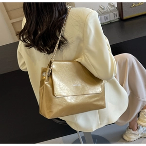Detail of metallic gold PU tote with metal chain strap and FASHION BAGS text