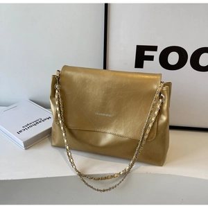 Detail of metallic gold chain shoulder bag with FASHION BAGS text and pleated texture