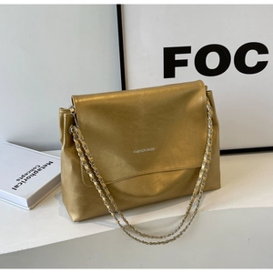 Detail of golden chain crossbody bag with white FASHION BAGS text on the flap cover
