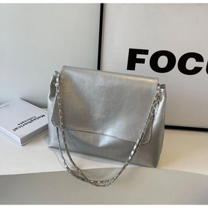 Detail of silver metallic textured tote bag with chain strap and fashion bags engraving