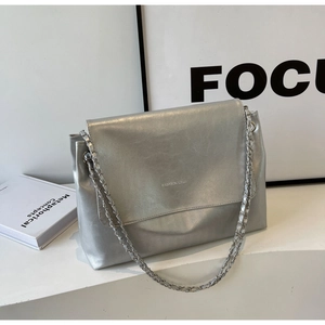 Detail view of silver tote bag featuring high-quality leather and metal chain strap