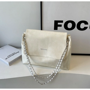 Detail of soft cream leather bag with silver chain strap and minimalist text logo