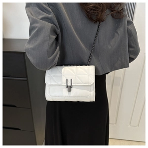 Sac à bandoulière blanc matelassé porté par un mannequin pour un look urbain chic