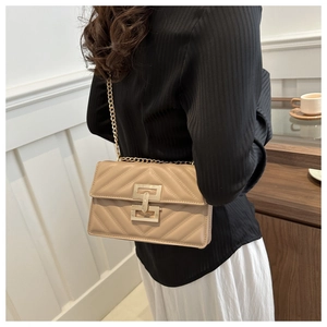 Detail of khaki quilted crossbody bag with gold chain strap and stylish metal clasp