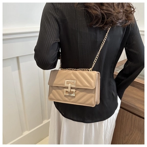 Detail of vintage beige crossbody bag with V-quilted texture and gold chain strap
