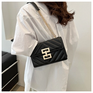 Detail of black quilted leather shoulder bag with gold geometric lock and chain strap