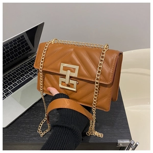 Detail of caramel brown quilted small crossbody bag with gold chain and metal twist lock