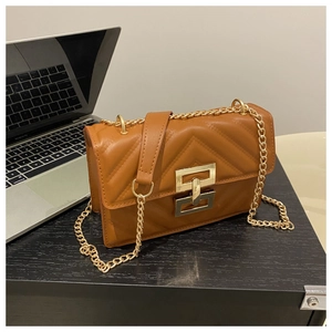 Detail of caramel brown quilted bag with gold chain strap and metallic closure