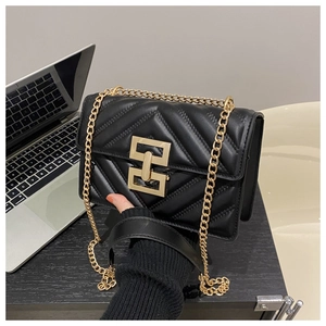 Close-up of black quilted shoulder bag with V-shaped stitching and gold square buckle