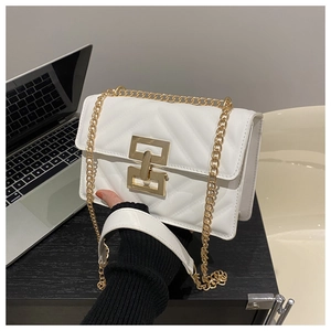 Detail of white quilted crossbody bag featuring a gold geometric lock and chain strap