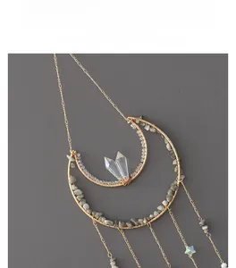 Detail of moon-shaped suncatcher with wire-wrapped natural stones and star charms