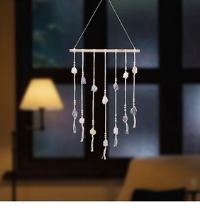 Macro view of handmade bohemian wall hanging featuring natural raw crystals and cotton rope