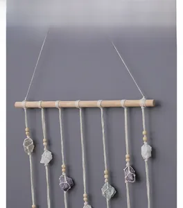 Detail of hand-woven cotton macrame wall hanging with natural raw crystal stones