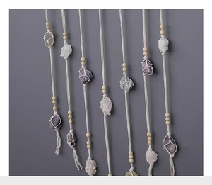 Detailed close-up of natural crystal gemstones and handwoven macrame cotton rope wall hanging