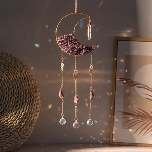 Detailed view of moon-shaped suncatcher with amethyst stones and colorful crystal prisms