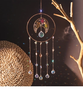 Detail of crystal suncatcher with rose gold moon frame and preserved dried flowers