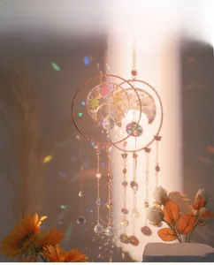 Detailed view of handmade suncatcher with crescent moon and crystal beads reflecting light
