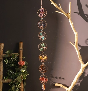 Macro view of handmade seven chakra crystal butterfly suncatcher with colorful stones