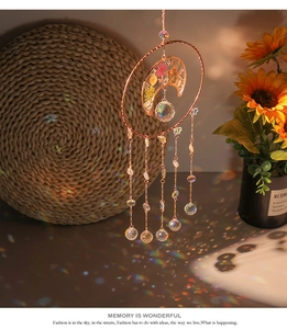 Detail of crystal suncatcher casting rainbow reflections on a desk with floral moon