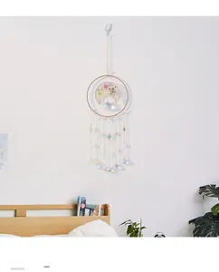 Detail of crystal suncatcher with golden crescent moon and colorful dried flowers