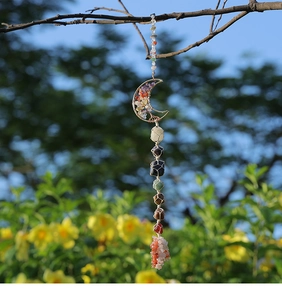 Macro shot of natural raw crystals in woven wire cages with a moon tree of life design