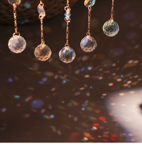 Set of 5 multifaceted crystal suncatchers with rose gold chains showing rainbow light