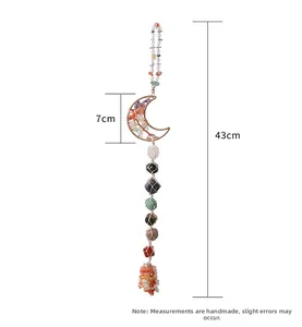 Detail showing colorful raw crystal stones inside a handmade moon-shaped wire pendant