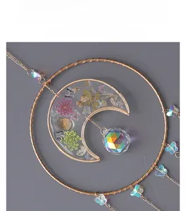 Detail view of crescent moon suncatcher with crystal ball and dried flower resin inlay