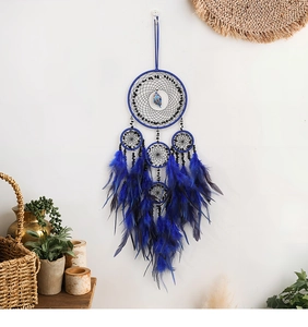 Dettaglio dell'acchiappasogni albero della vita blu con piume e cristalli sulla parete