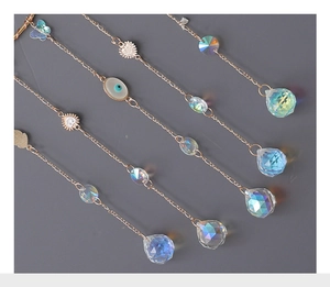 Detailed view of suncatcher crystal prisms with evil eye and butterfly charms in gold