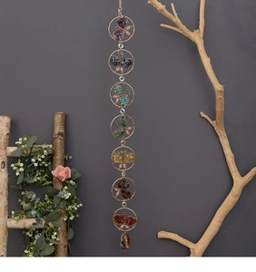 Detail of seven chakra crystal butterfly wall hanging with natural stones in gold frames