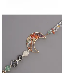 Detail of moon-shaped golden wire pendant with crushed stone tree of life and woven net