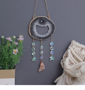 Detail of bohemian agate slice wind chime with rose quartz pendant and metallic beads