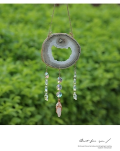 Detail of bohemian agate slice wind chime with crystal beads and pink quartz pendant