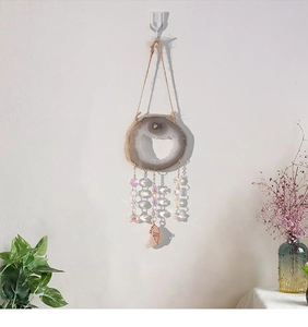 Detailed view of agate slice wind chime with rainbow crystal beads and rose quartz pendant