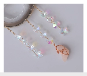Detail of gold chain with iridescent AB coated beads and pink quartz stone pendant