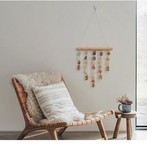 Detail of colorful raw crystal stones hanging from a wooden stick as wall decor