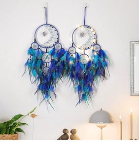 Detail of dream catcher featuring blue feathers and glowing LED lights for wall decor