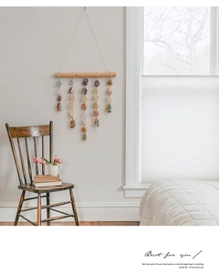 Detail of handmade crystal suncatcher with natural stones hanging on a wooden stick