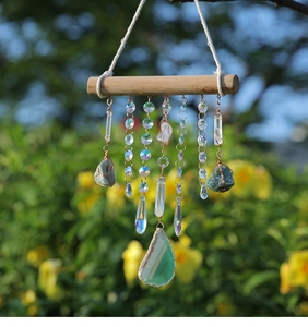 Close-up of handmade wall hanging with natural crystal pillars and green agate slice