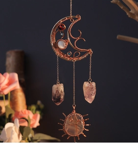 Close-up of rose gold wire-wrapped moon ornament with amethyst and agate stones