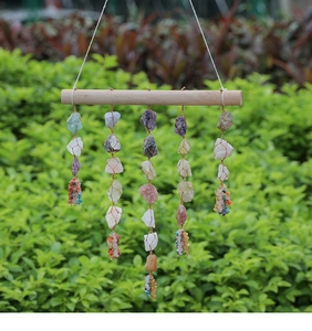 Detailed shot of handmade bohemian wall hanging with raw healing crystals on a wood stick