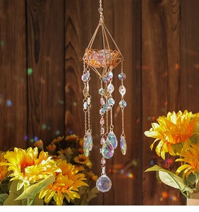 Detail of geometric suncatcher with golden frame and faceted crystal prisms on wood