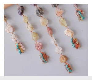 Close-up of bohemian wall hanging with colorful raw crystals and woven cotton cord