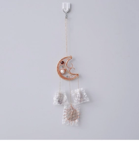 Detail of moon-shaped wire wrapped wind chime with colorful beads and crystal stones