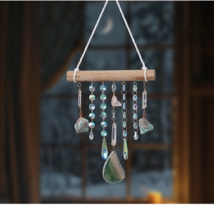 Detail of bohemian suncatcher with natural crystal columns and agate slices on a wood pole