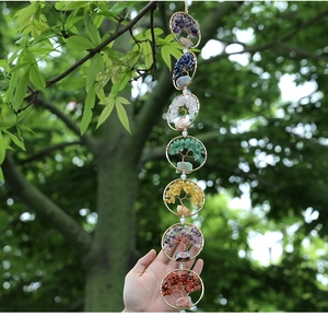 Close-up of handmade 7 chakra tree of life hanging ornament with natural raw crystals