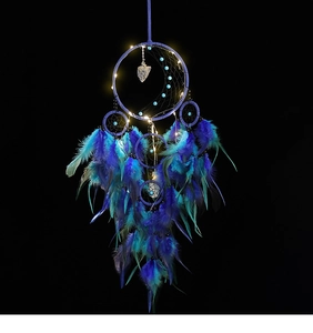 Close-up of handmade dream catcher with blue feathers and glowing LED lights for wall decor