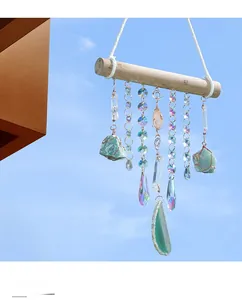 Detail showing natural crystal prisms and green raw stones hanging on a wooden wall decor