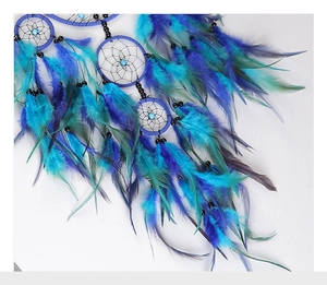 Detailed view of handmade dreamcatcher with blue feathers and crystal beads
